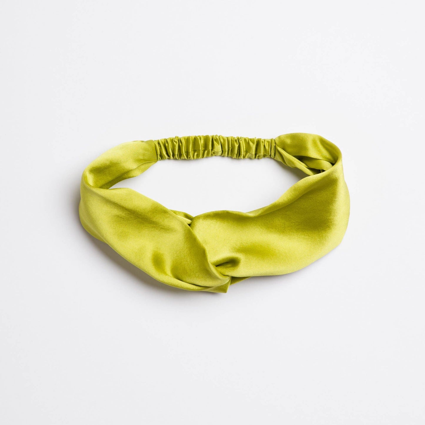 Green satin headband on a light gray background