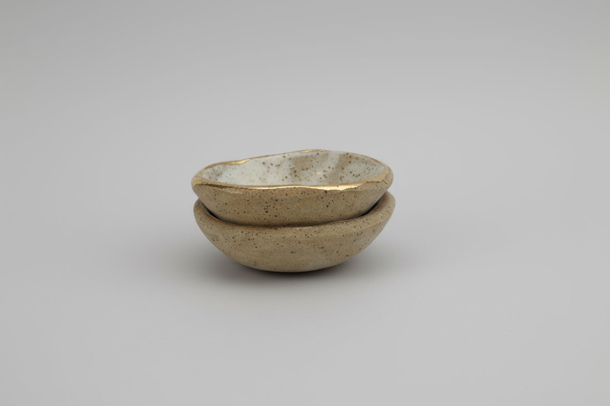 Two stacked ceramic bowls on a marble surface with a tiled wall background