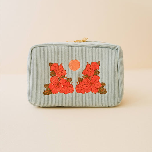 Light blue pouch with floral embroidery on a beige background