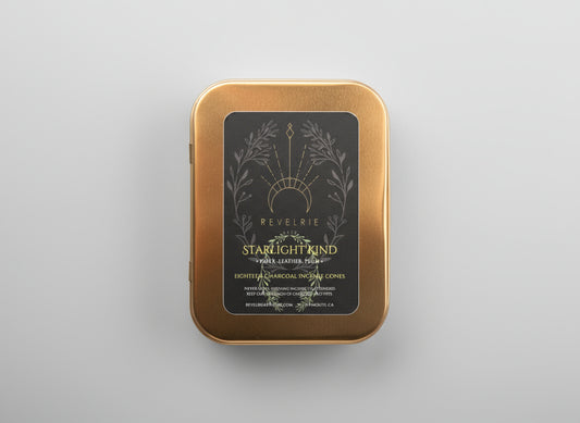 Gold tin with 'Revelrie' label on a dark background