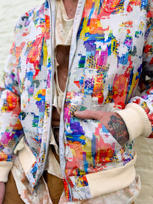 Colorful jacket with abstract patterns worn by a person.