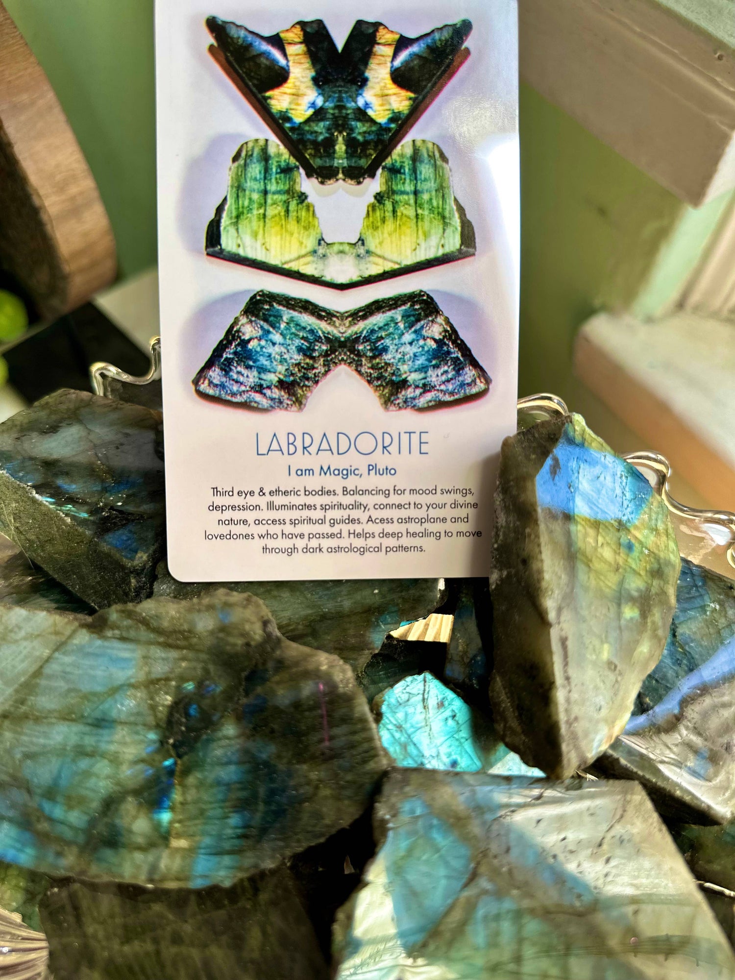 Labradorite stones with a card detailing its properties on a blurred background