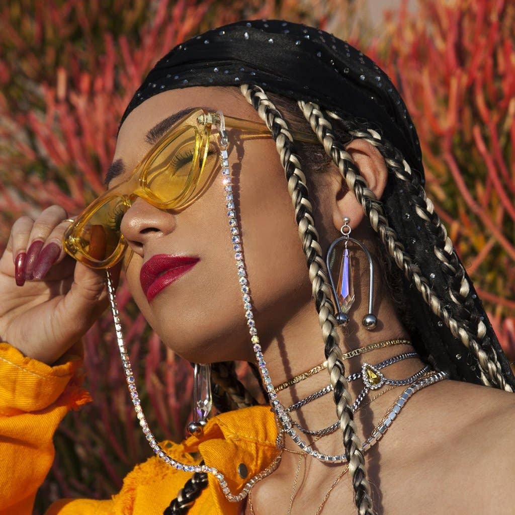 Woman wearing yellow sunglasses with a colorful background