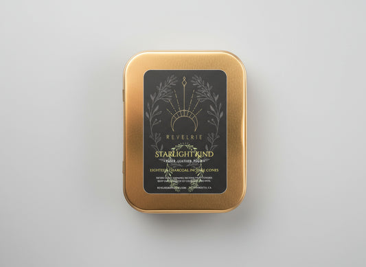 Gold tin with 'Revelrie' label on a dark background