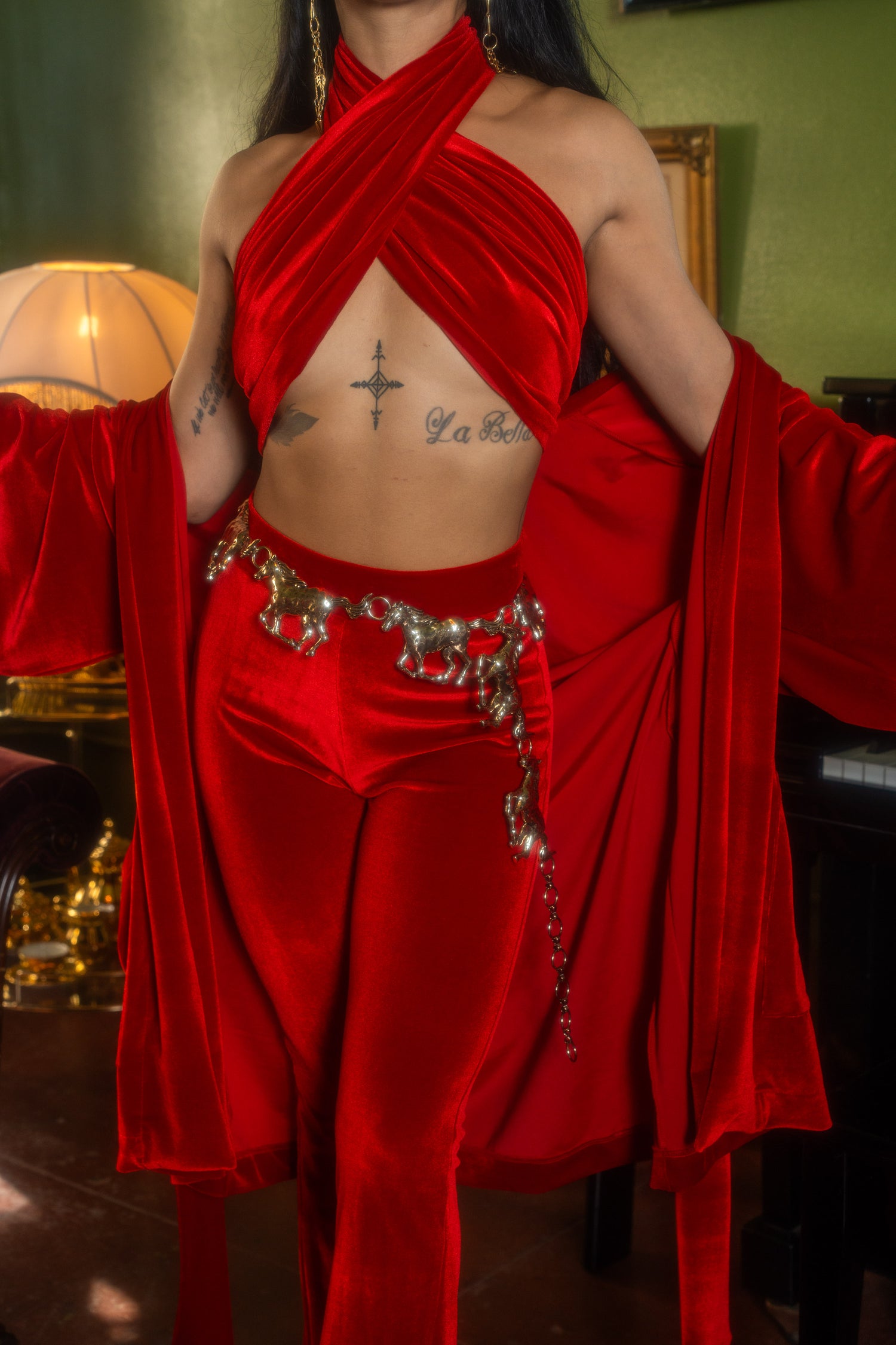 Person wearing a red velvet outfit with gold accents in an indoor setting.