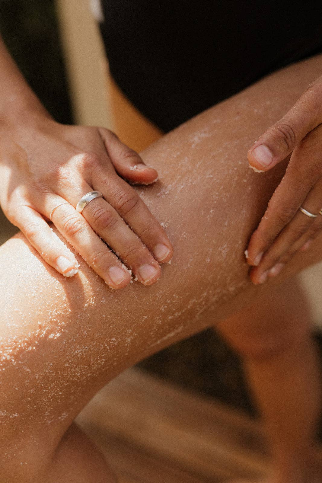 Person applying a product to their leg with a blurred background