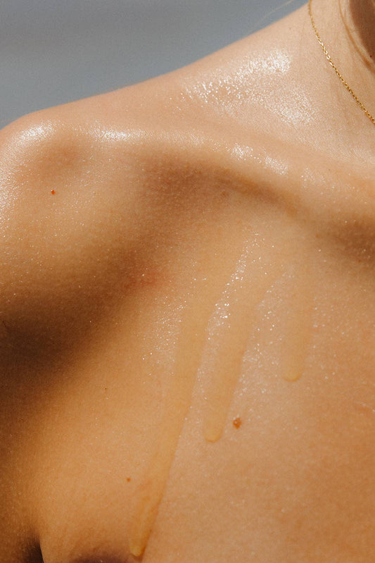 Close-up of a person's shoulder with oil on their skin