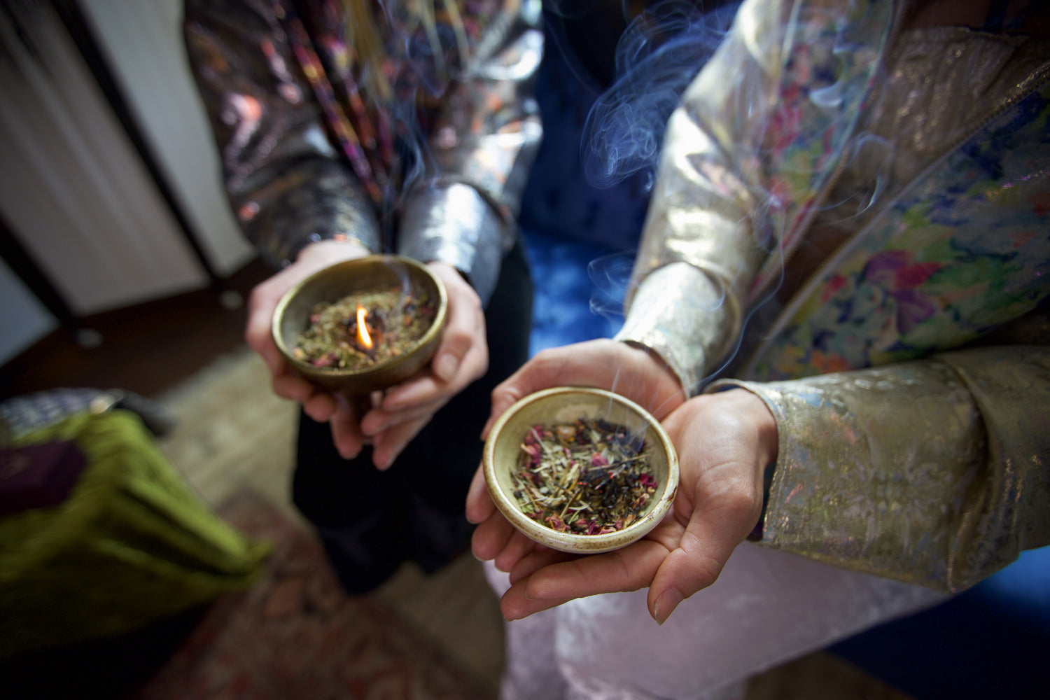 two women holding bowls of loose incense